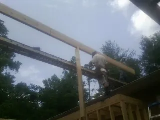 Carpenter setting a ridge beam over a new addition frame — Ice Dam Removal by Roofing Brothers in Valley Falls