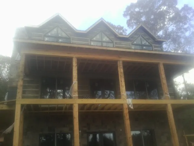 Dormers and porch framing on a large log home under construction — Roof Coating work by our crew in Valley Falls